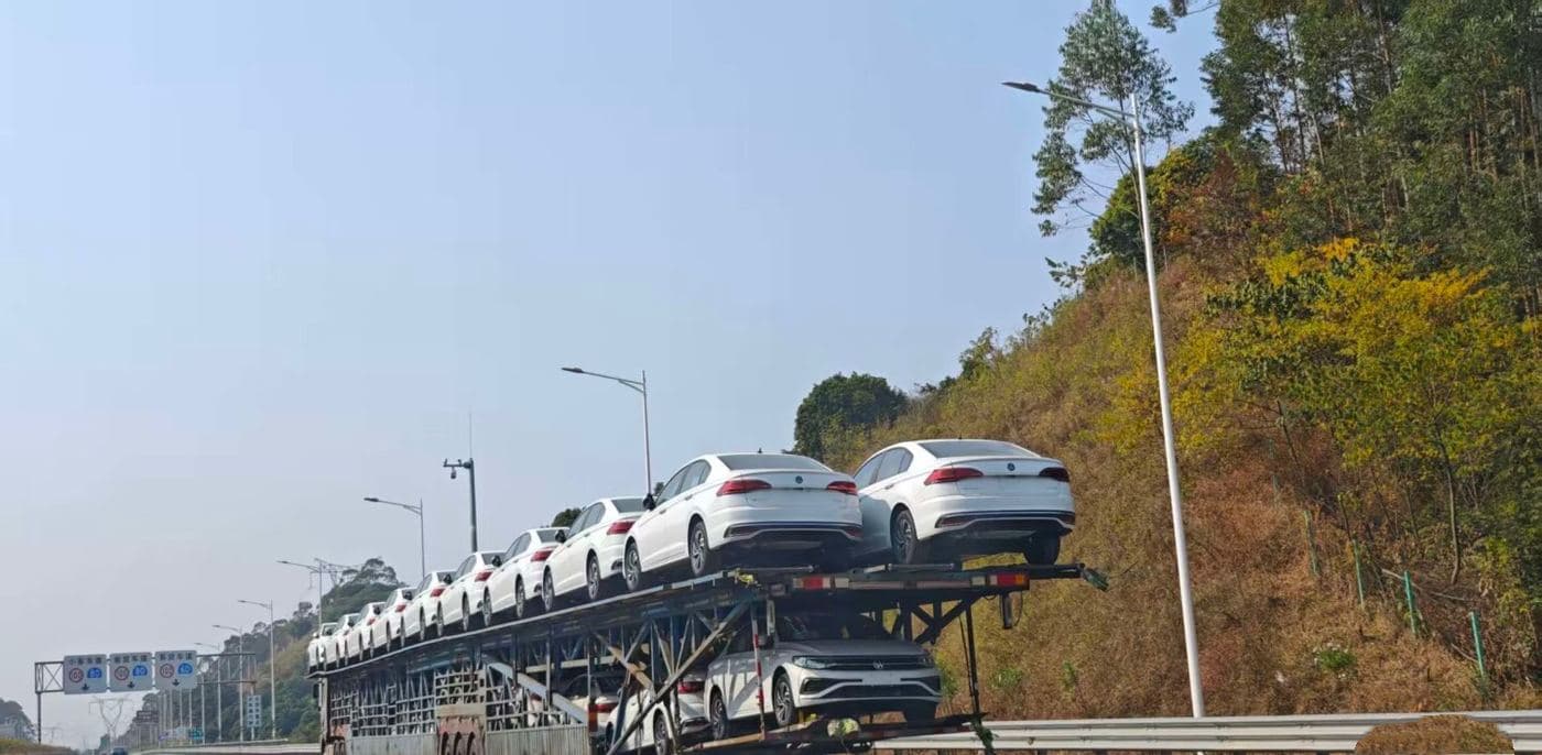 Car-carrier truck transporting new sedans on a highway