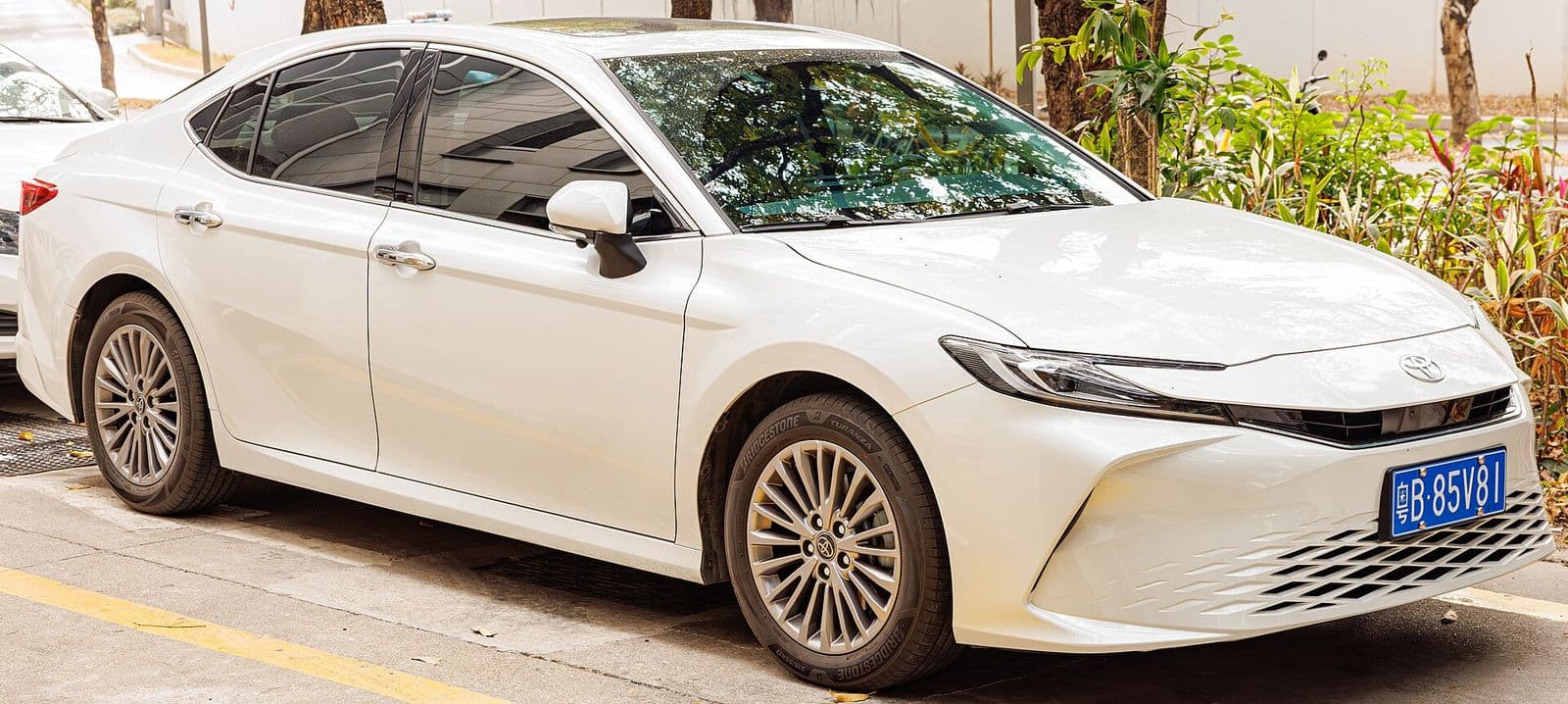 White Toyota Camry XV80 hybrid, front three-quarter view