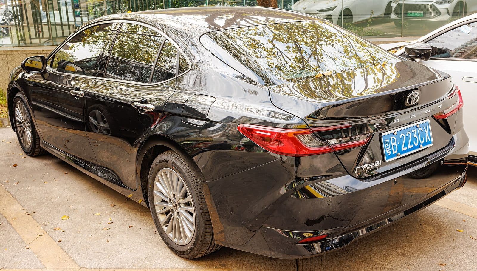 Toyota Camry XV80 hybrid in black, rear three-quarter view